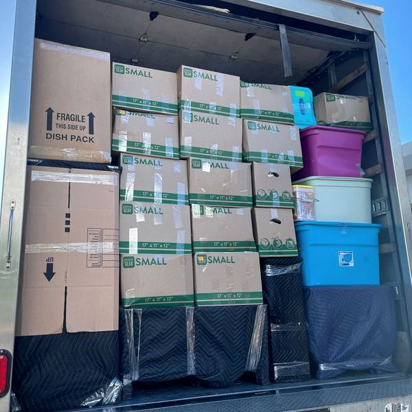 Truck loaded to the roof with a tight wall of boxes and plastic totes